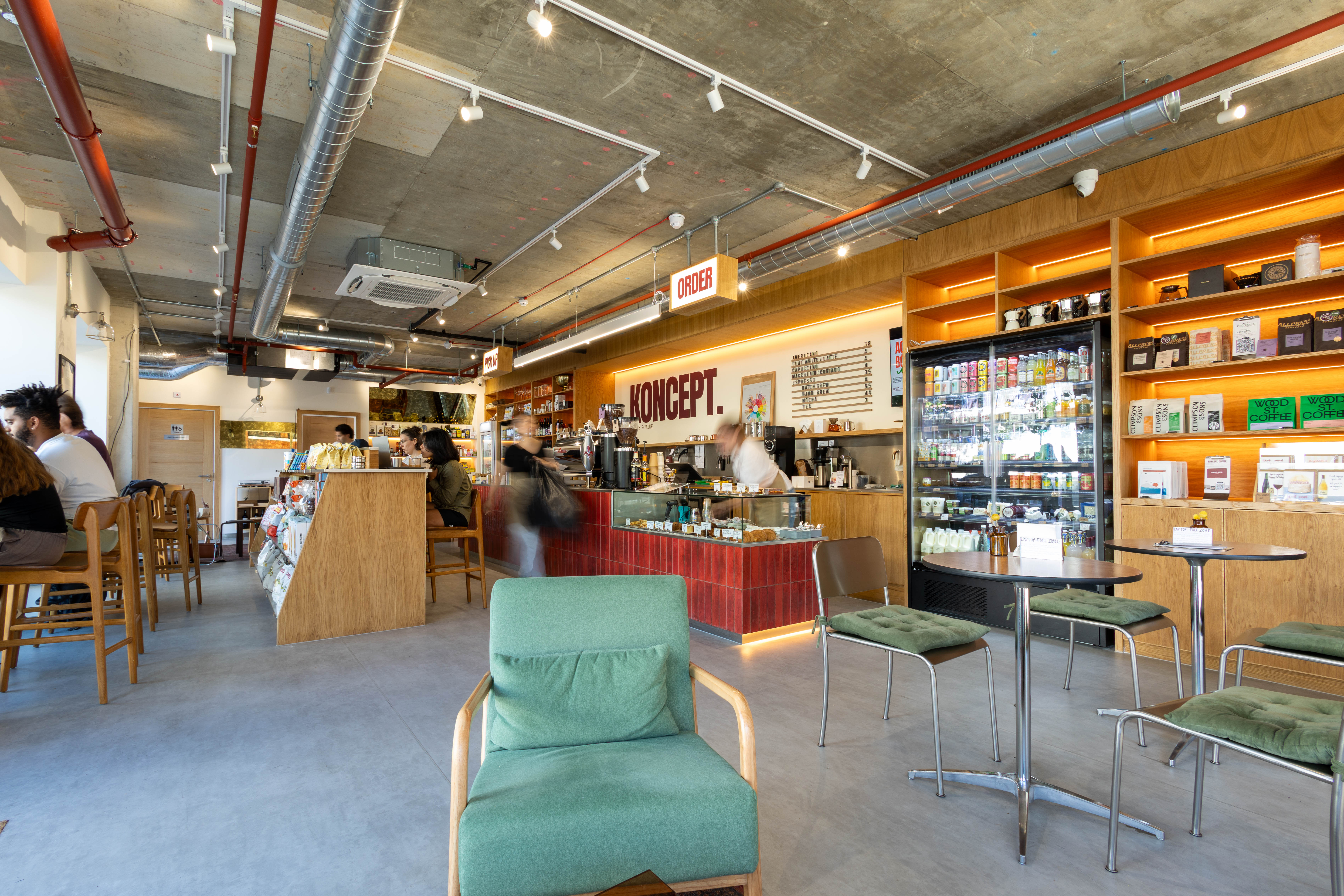 The seating area and red-tiled service counter at Koncept Coffee & Wine, a café fit-out by K&K Studio