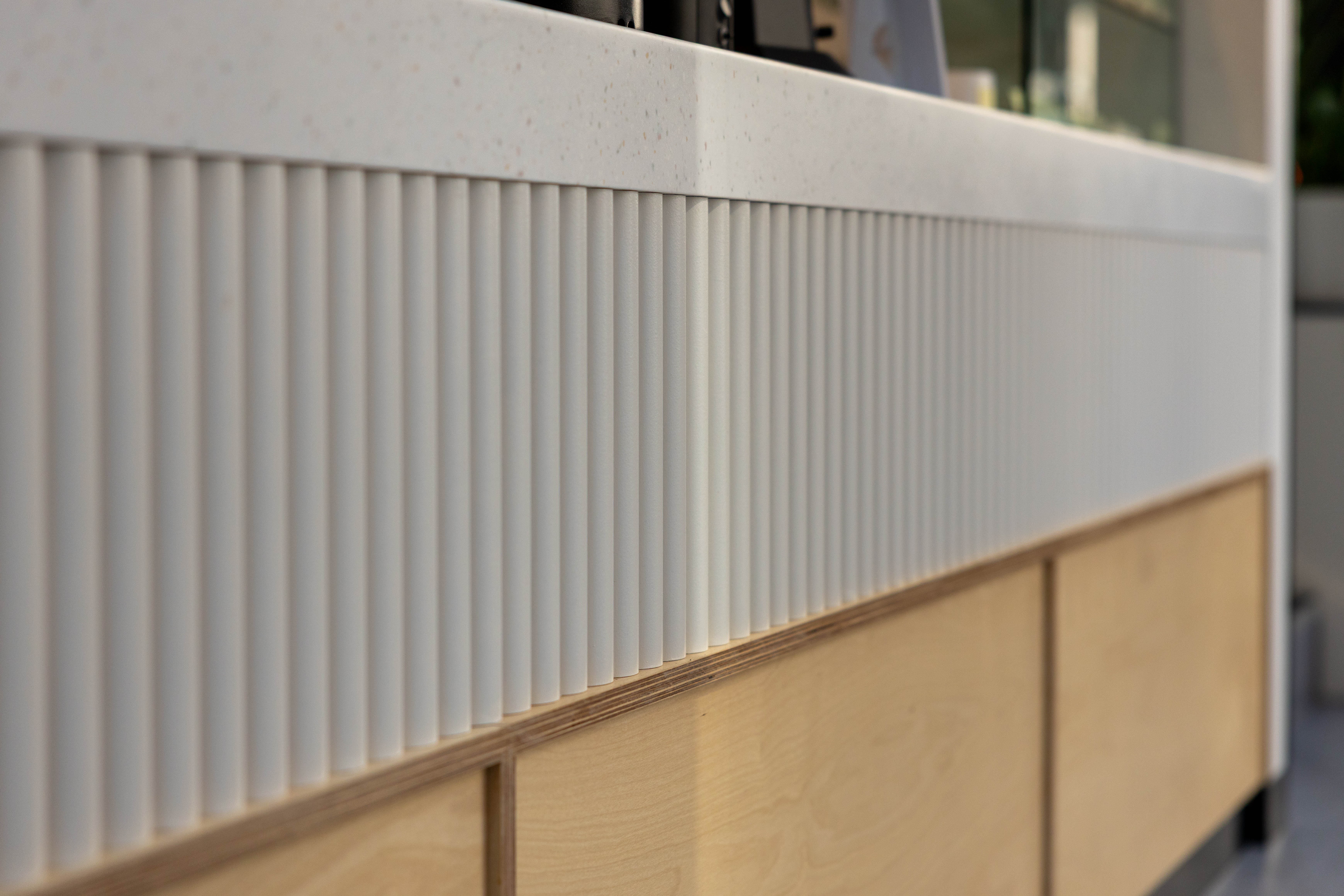Track lighting and services run below the soffit of the upper seating volume